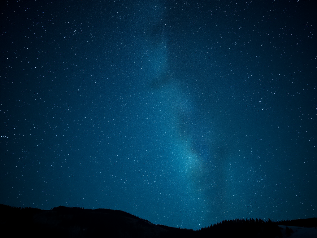 A clear winter night sky filled with stars, showcasing the Milky Way against a dark blue background, with silhouettes of mountains at the bottom.